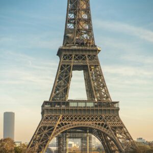 Close-up of the Eiffel Tower in Paris, showing its intricate lattice structure against a clear sky.