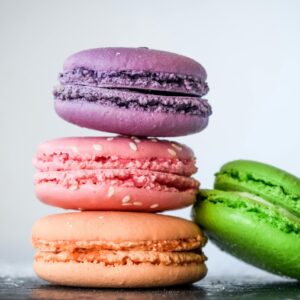 A vibrant stack of colorful macarons with sesame seeds, perfect for dessert lovers.
